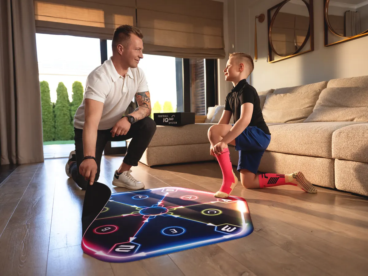 A dad and his son rolling out the Athlekid mat at home